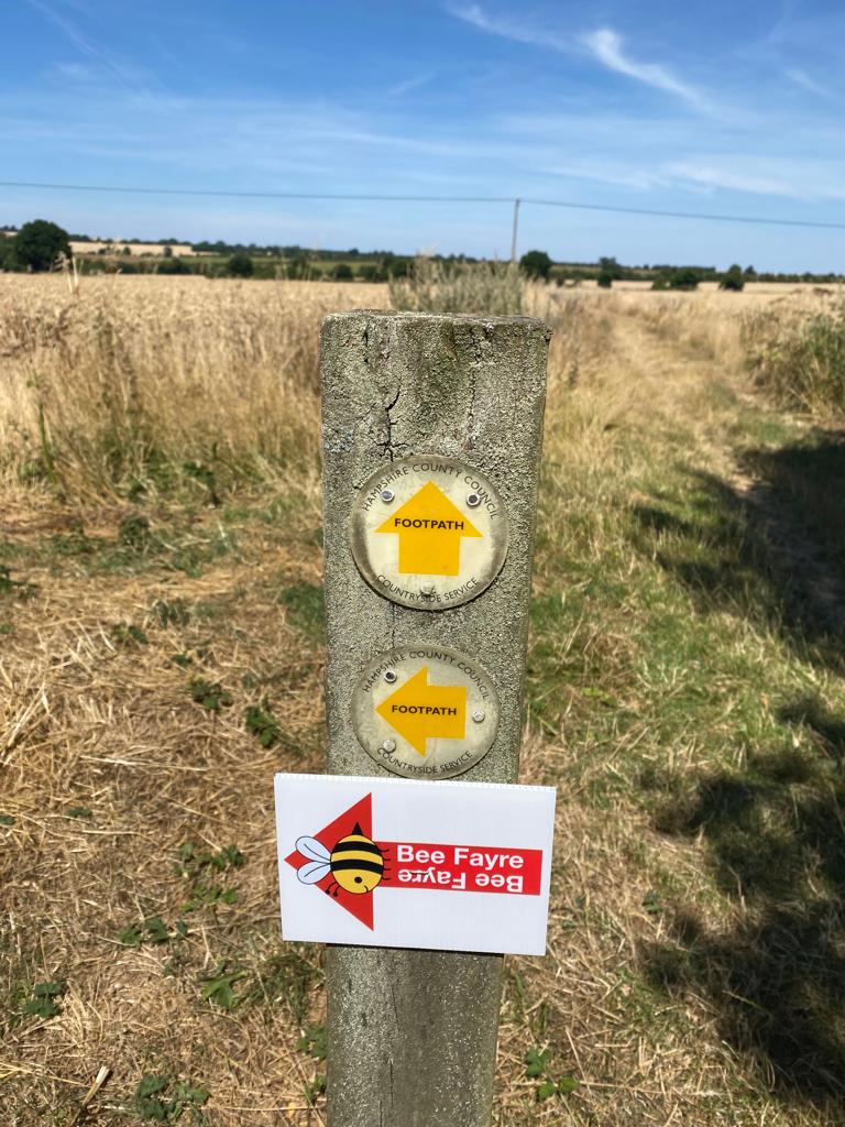 a countryside sign pointing to the bee fayre